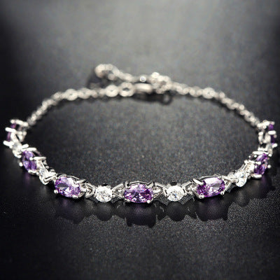Silver bracelet with purple gemstones on a dark background
