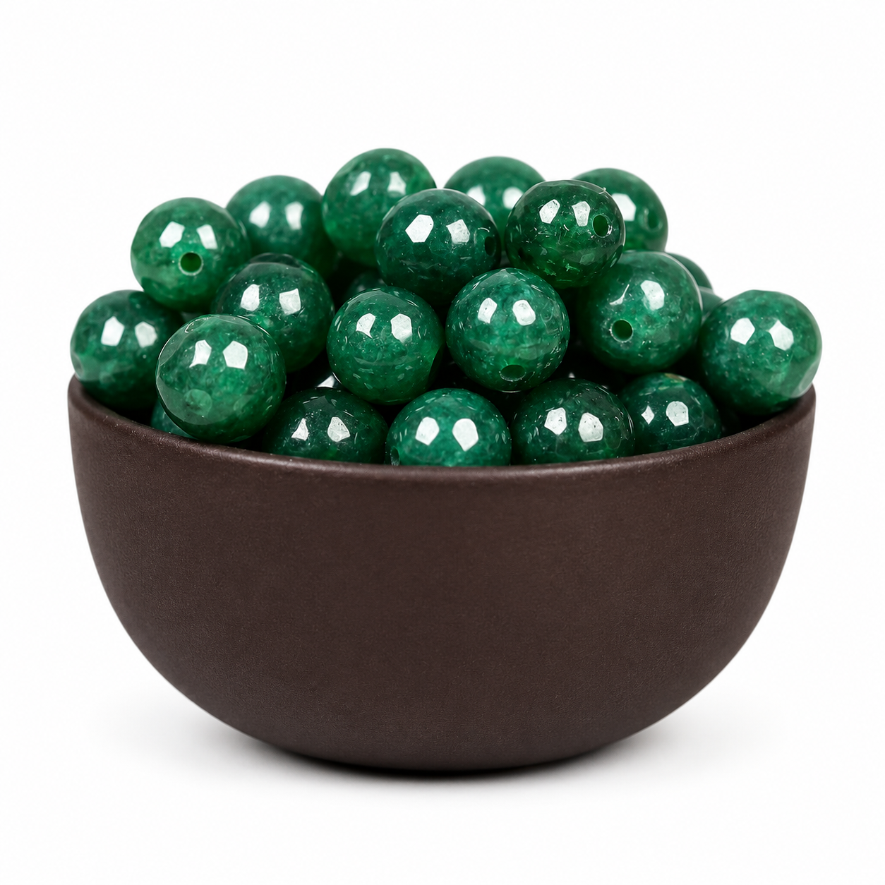 A bowl filled with glossy green faceted gemstone beads on a clean white background.