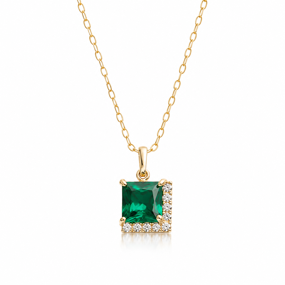 Square emerald green gemstone pendant necklace in gold with sparkling crystal accents on a clean white background.