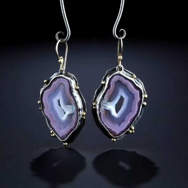 Purple agate earrings with silver frames on a dark background