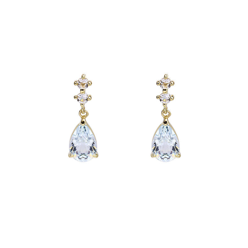 Gold earrings with clear teardrop-shaped gemstones on a white background