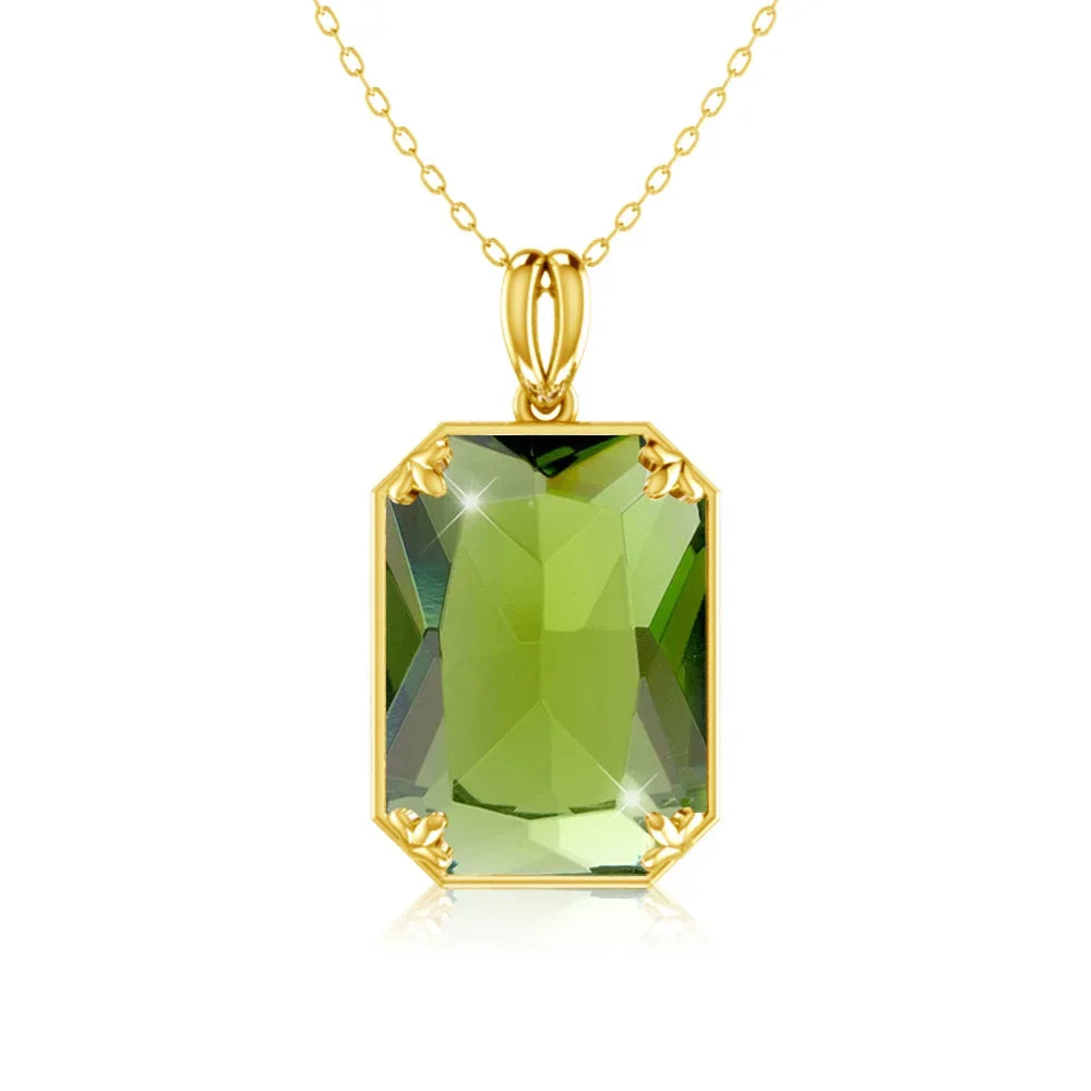 Gold necklace with a green gemstone pendant on a white background
