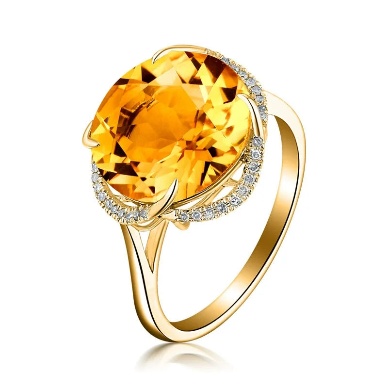 Gold ring with a large yellow gemstone on a white background