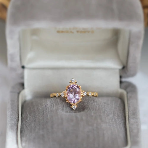 Gold ring with a pink gemstone in a jewelry box
