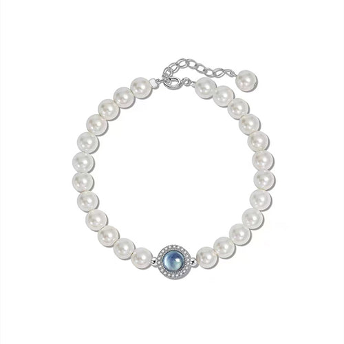 Pearl bracelet with a central blue gemstone on a white background