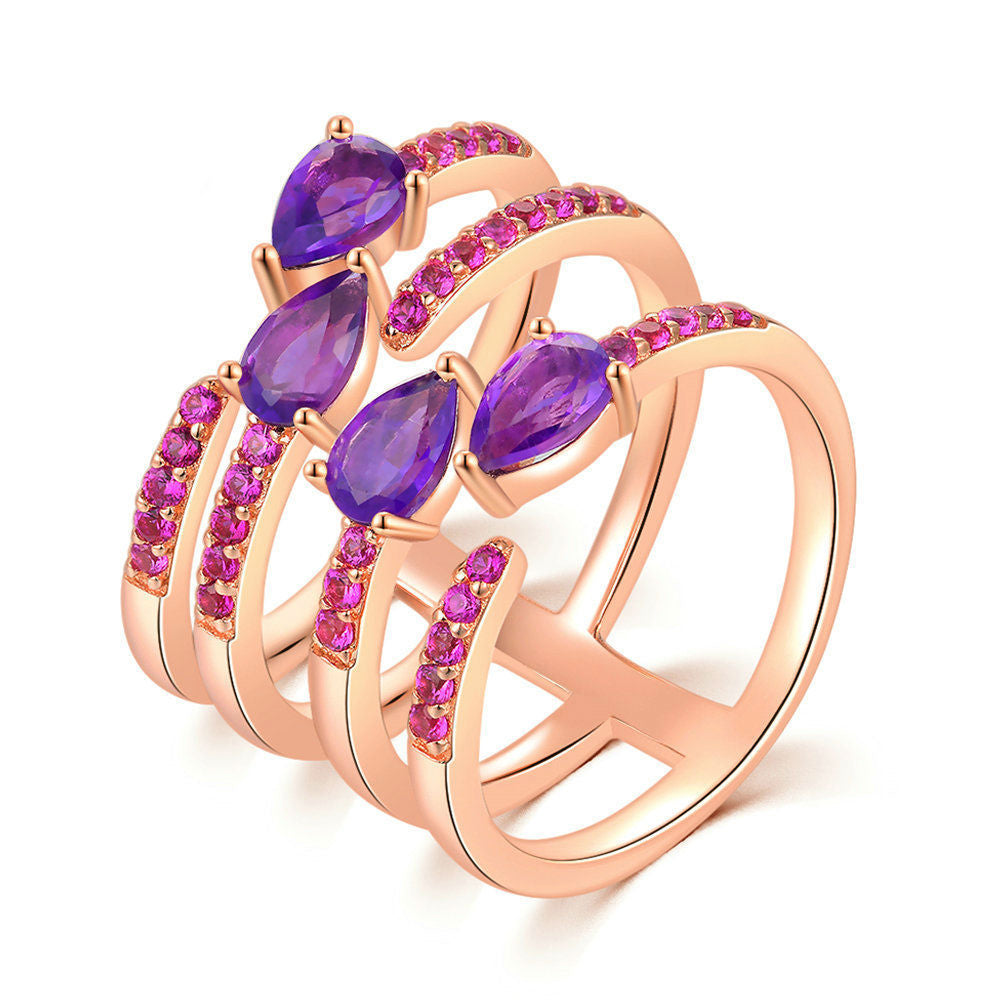 Rose gold ring with purple and pink gemstones on a white background