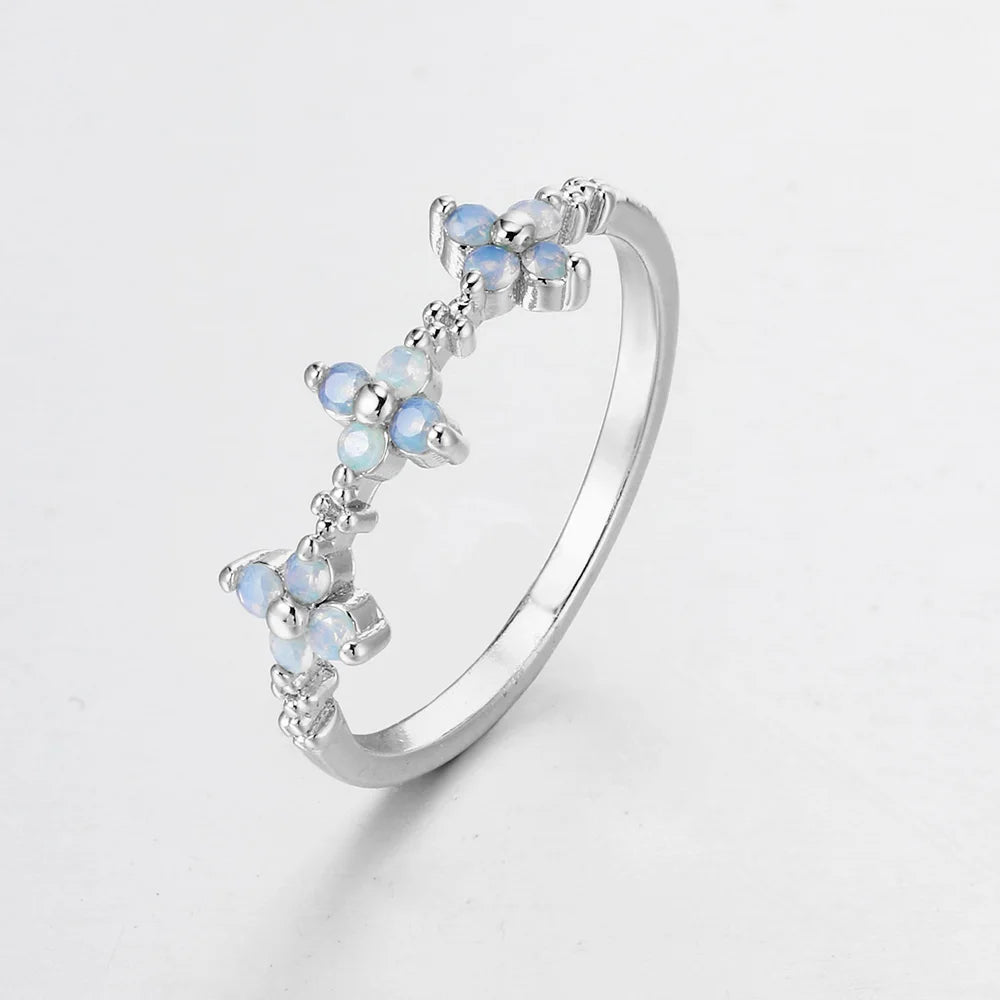 Silver ring with blue gemstones on a light gray background