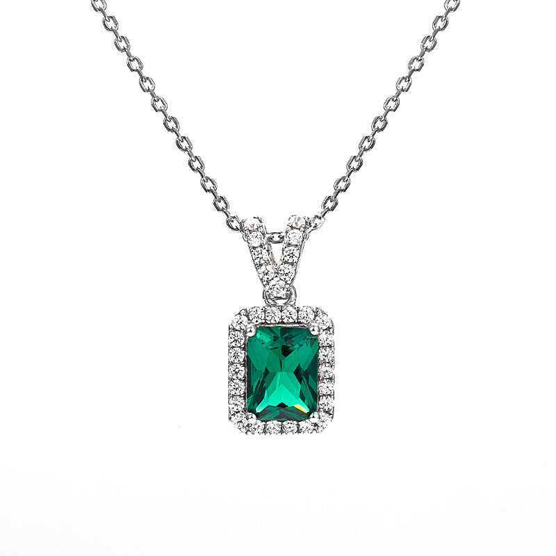 Sterling silver emerald green halo pendant necklace with an emerald-cut gemstone on a clean white background.