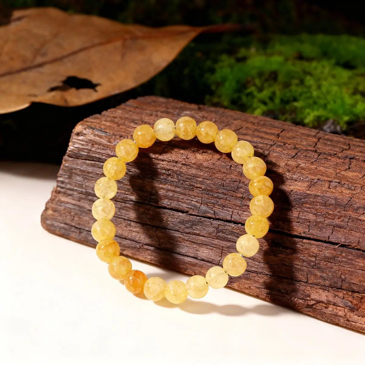 Yellow beaded bracelet on a wooden log with a natural background